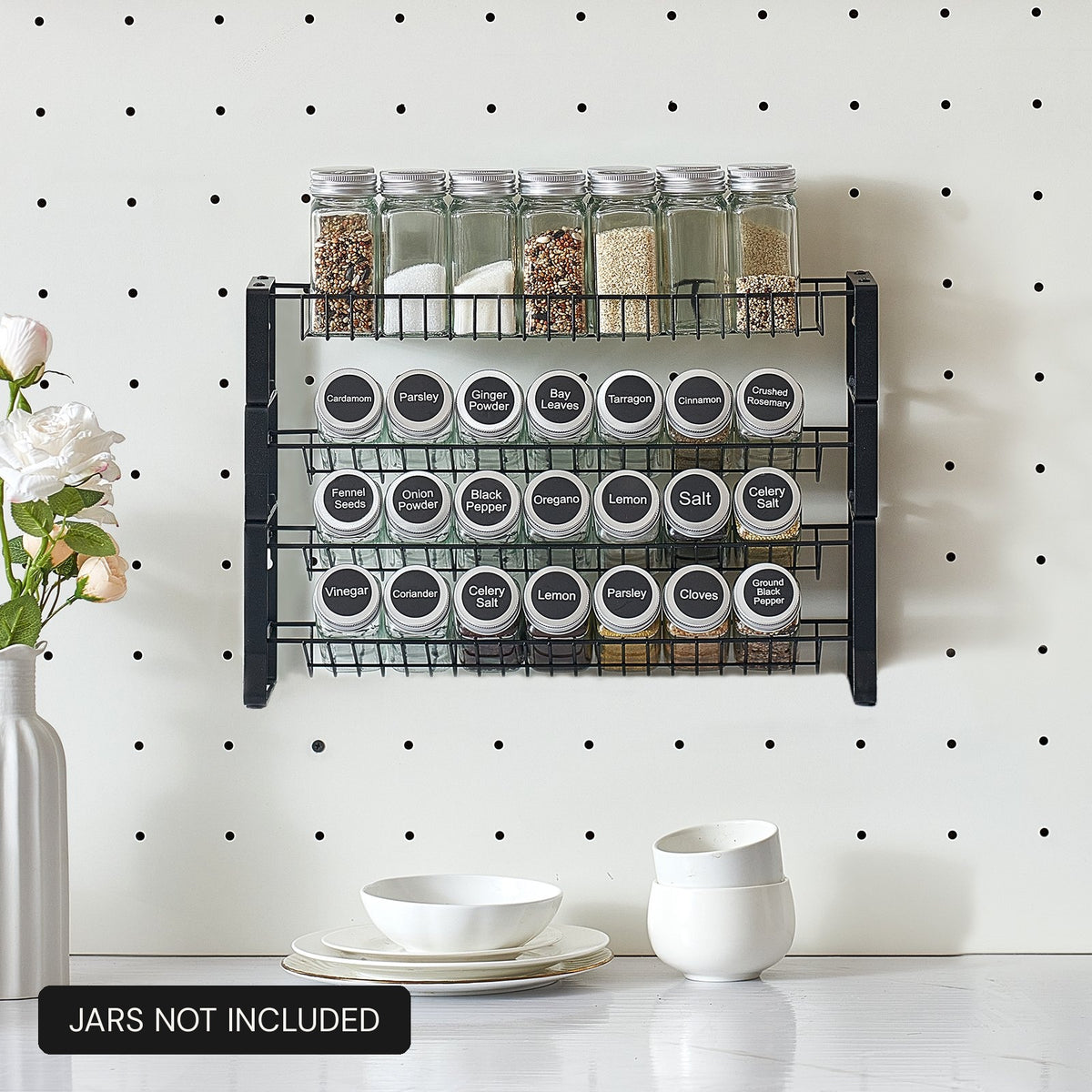 Tiered spice rack organizer mounted on a kitchen pegboard wall holding four rows of labeled spice jars